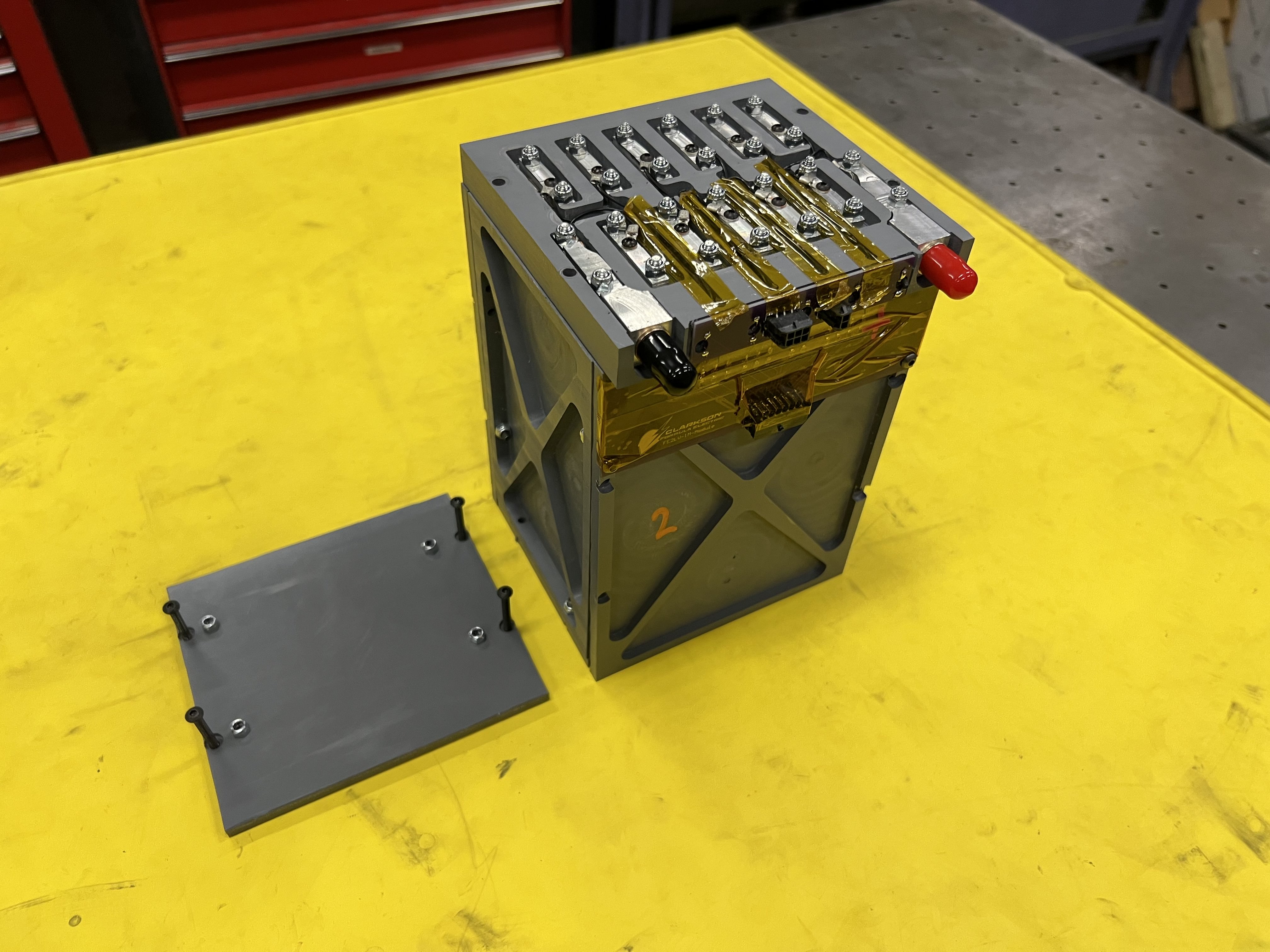 An opened battery module showing the machined clamps that secure and connect the pouch cells' tabs