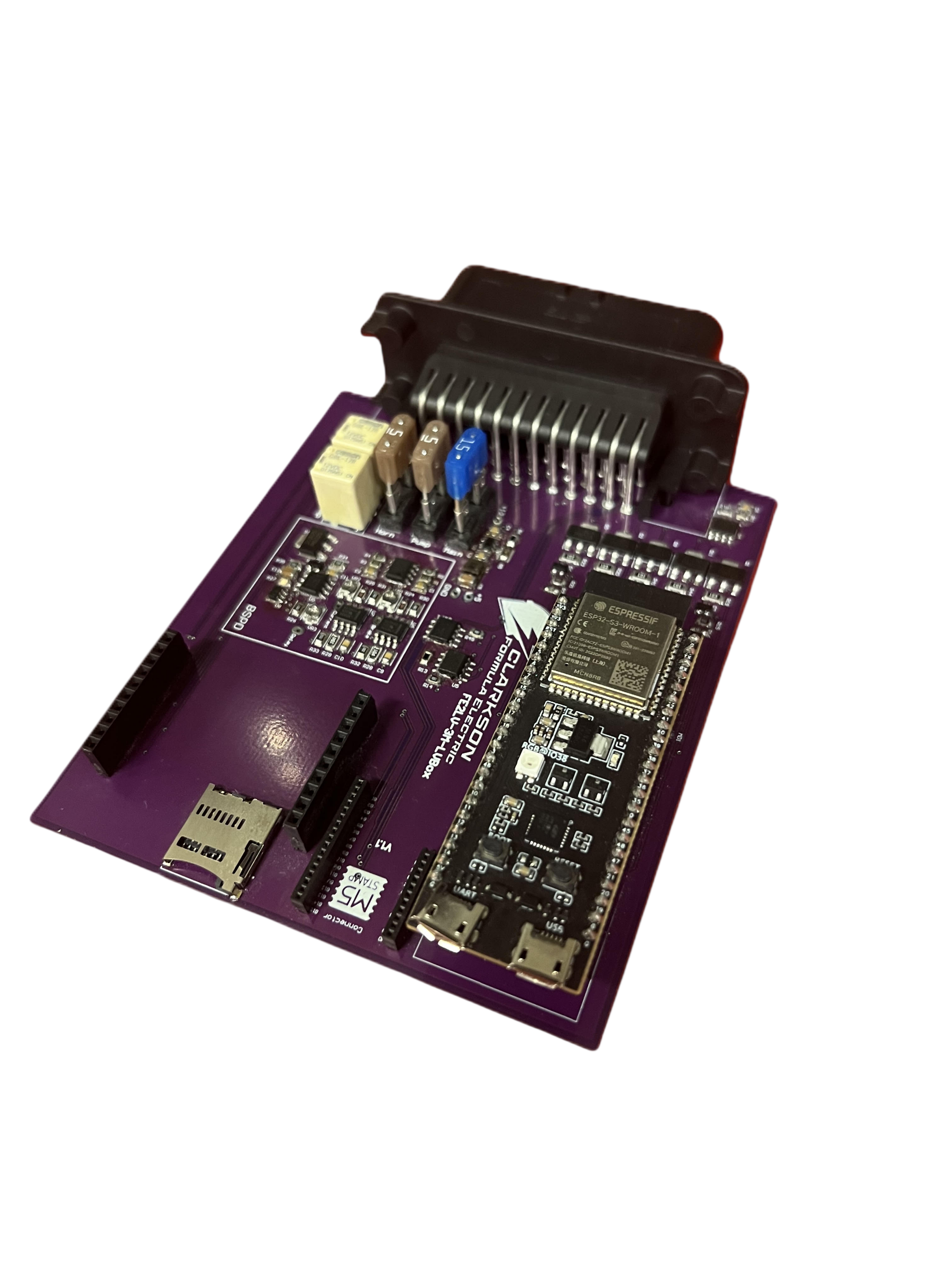 The ECU board photographed against a transparent background &mdash; a purple PCB carrying a microcontroller module, a microSD card slot, relays, blade fuses, and a multi-pin board-edge connector