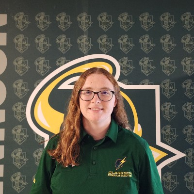 Isabelle Wells in a green Clarkson Formula Electric polo, in front of a Golden Knight backdrop